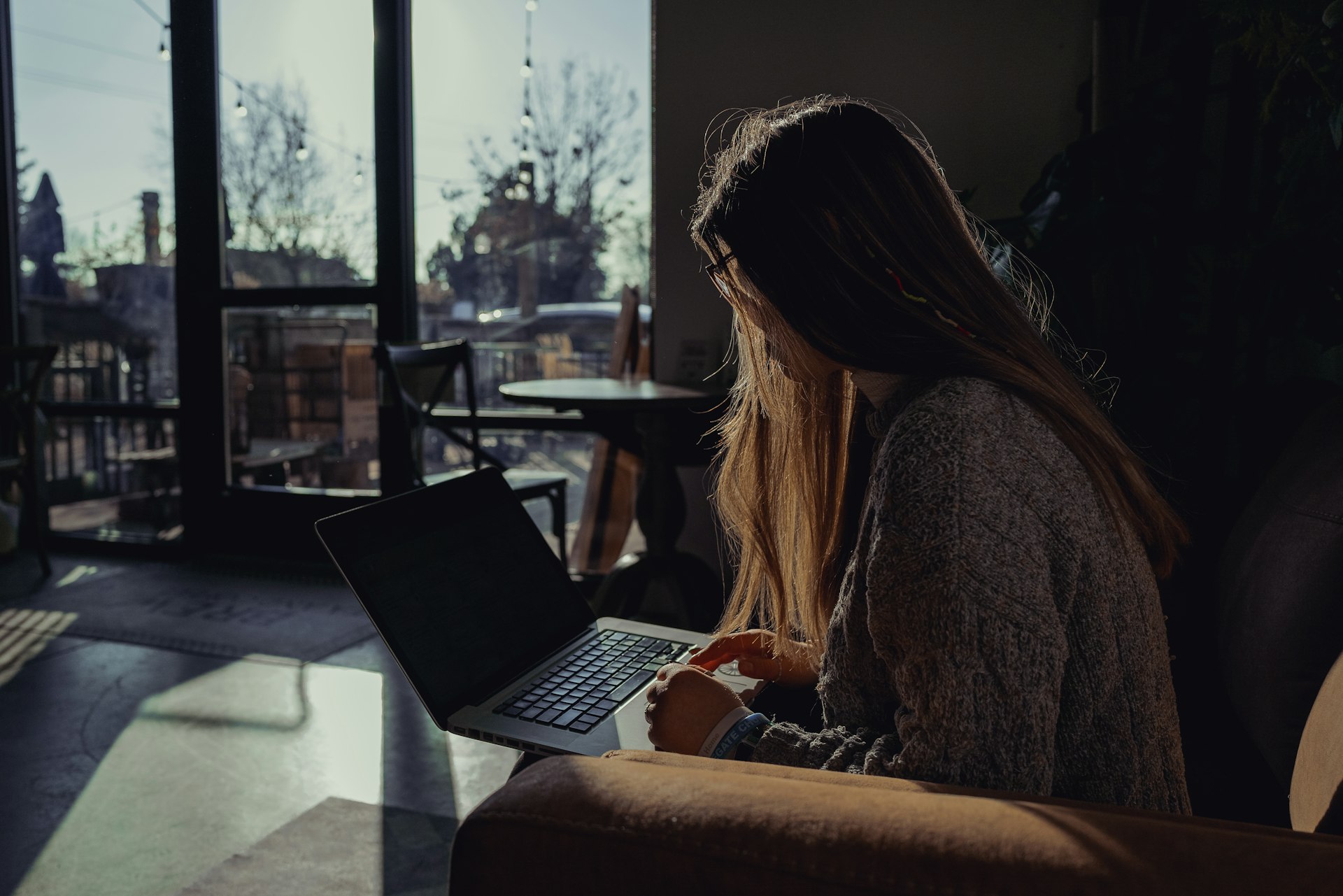 woman in gray sweater using laptop computer